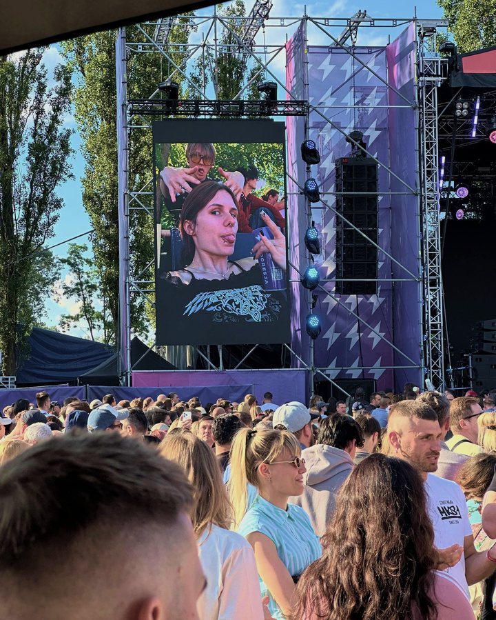 Outloud Festival: the stage with a guest photo on the screen and the crowd in front